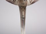 silver spoon with a flower shaped handle on a gray background