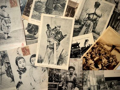 de nombreuses vieilles photos de personnes d'origine asiatique posées sur une table