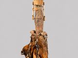 une image représentant une statue de femme debout sur une souche d'arbre