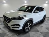 un 4x4 blanc garé sur un sol en damier dans un garage