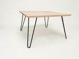une table en bois avec des pieds en épingle à cheveux noirs sur fond blanc