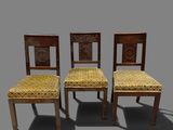three wooden chairs with yellow upholstered seats on a gray background