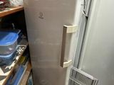 a refrigerator in the corner of a room with a lot of boxes