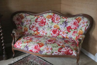 a floral couch in a room with a rug on the floor