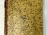 un vieux livre posé sur une table recouverte d'un tissu blanc