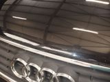 a close up of a car ' s grille with a reflection of a building in the background