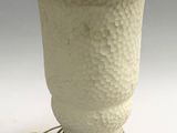 a white vase that has a cord attached to it