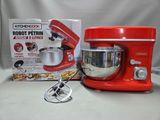 un mixeur rouge et une boîte de nourriture posés sur une table
