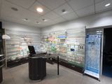 une photo d'un bureau de pharmacie avec un bureau et un réfrigérateur