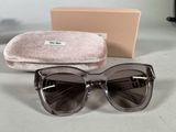 sunglasses and case on a table next to a pair of glasses
