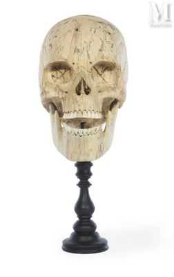 an image of a wooden skull head on a stand on a white background