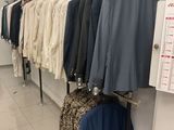 a lot of clothes hanging on a rack in a room