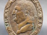 a bronze plaque of a man in profile