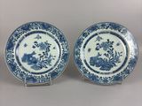 two blue and white plates with flowers and birds on them