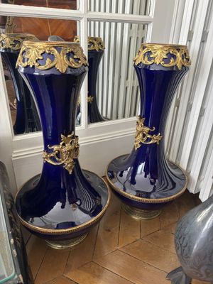 une paire de grands vases bleus, ornés chacun de détails dorés