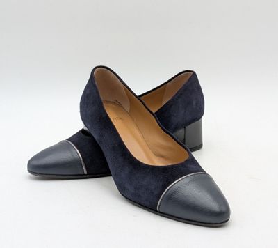une paire de chaussures noires et grises posées sur une surface blanche