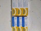 deux tubes de dentifrice posés sur une table blanche