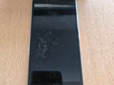 Un iPhone est posé sur une table en bois, à côté d'une boîte.