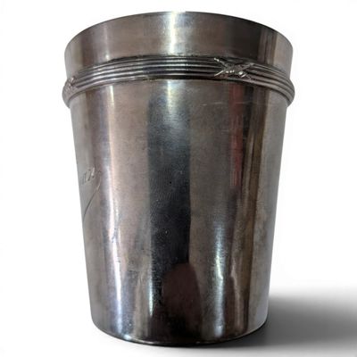 a silver cup that is sitting on a white surface