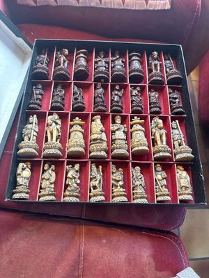 plein de pièces d'échecs dans une boîte posée sur le canapé
