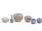 un ensemble de vases et de bols bleus et blancs posés sur une surface blanche