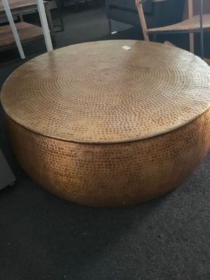 a round table with a wooden top in the middle of a room