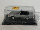 a small toy car in a clear box on a white surface
