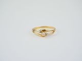a gold ring with two diamonds on it