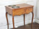 a small wooden table with a bowl on top of it
