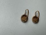 a pair of gold earrings with a face of a woman