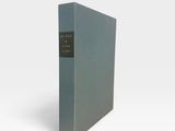 un livre bleu à la couverture noire posé sur une surface blanche
