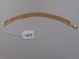 gros plan d'un bracelet en chaîne en or avec une étiquette de prix