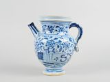 a blue and white vase with a handle on it