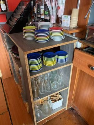 de nombreuses assiettes et verres empilés sur une étagère dans la cuisine