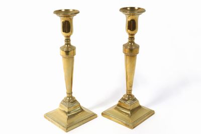 two gold candlesticks on a white background