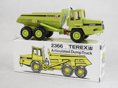 a green toy dump truck sitting on top of a box