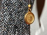 a close up of a person ' s jacket with a gold coin on it