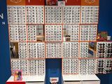 two rows of glasses on display in front of a blue wall