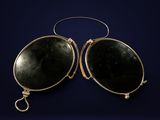 a pair of oval shaped black glass earrings with a gold clasp