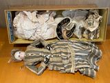 a doll that is laying on the floor next to a box