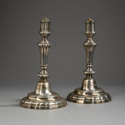 une paire de bougeoirs en argent sur fond gris