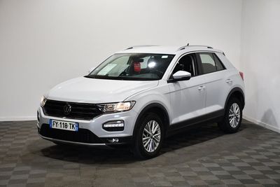 un SUV Volkswagen blanc garé dans une pièce au sol carrelé