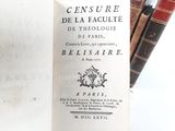 a book that is open on a table next to some books
