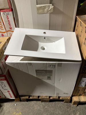 a white sink sitting on top of a wooden pallet