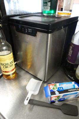 une bouteille d'alcool, une spatule et une bouteille d'alcool posées sur un plan de travail
