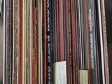 a lot of records stacked on a shelf in a room