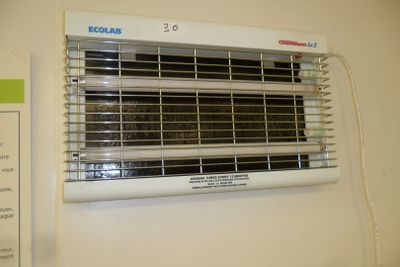 a white wall mounted heater on the wall next to a sign