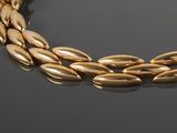 a close up of a gold necklace on a black surface