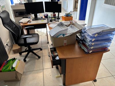a desk with a lot of papers on it and a computer monitor