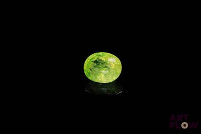 un gros plan d'une pomme verte posée sur une surface noire